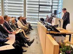 Ein Mann am Rednerpult vor Publikum