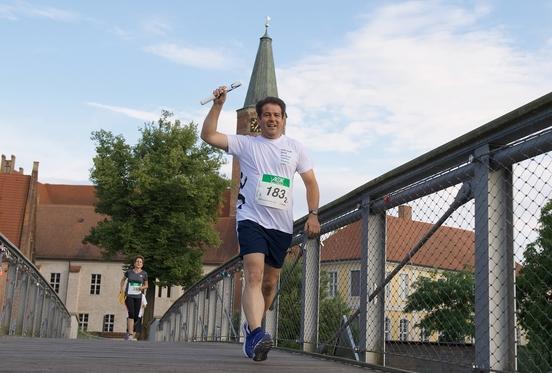 Steffen Scheller als Staffel-Teilnehmer, läuft über die Fußgängerbrücke beim Brandenburger Dom 