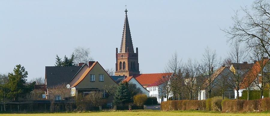 Verschiedene Wohnhäuser mit einem Kirchenturm im Hintergrund 