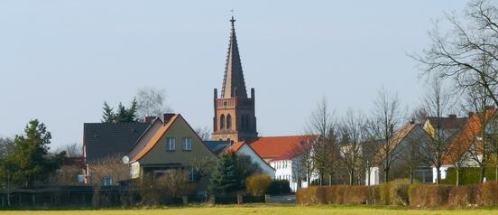 Profilbild von Wust mit dem Kirchturm und Wohnhäusern von Natur umgeben