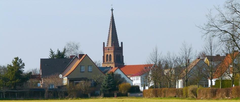 Verschiedene Wohnhäuser mit einem Kirchenturm im Hintergrund 