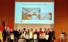 Eine Menschengruppe erhält eine Auszeichnung.