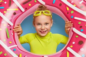 Ein Kind schaut durch einen aufgeblasenen Donut.