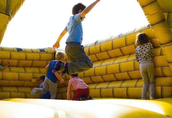 Kinder springen auf einer gelben Hüpfburg. Foto: Lukas/Pexels
