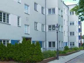 Ein Wohngebäude mit Bepflanzung vor den Eingängen