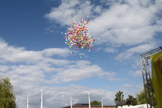 Zur Eröffnung steigen bunte Luftballons auf.
