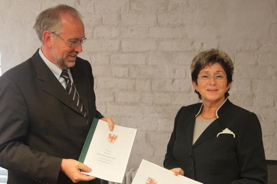 Stiftungsdirektor und Oberbürgermeisterin mit den Urkunden des unterschriebenen Erbbaurechtsvertrag
