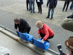 Oberbürgermeisterin und Minister montieren die ersten neuen Sitzschalen.