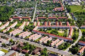 Luftbild mit vielen roten Dächern und Grünflächen