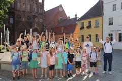 Gruppenbild vor dem Brunnen am Altstädtischen Rathaus. Die Kinder heben die Arme.