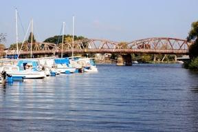 Brücke über dem Gewässer mit Segelbooten im Vordergrund