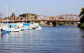 Brücke über dem Gewässer mit Segelbooten im Vordergrund