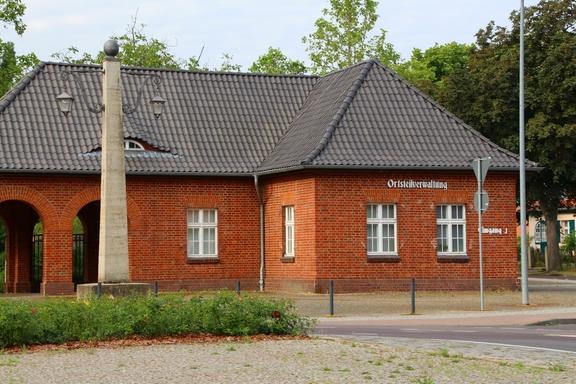 Ein rotes Backsteinhaus mit grauem Dach und der Aufschrift "Ortsteilverwaltung".