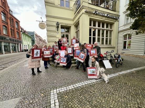 viele Menschen stehen in einer Gruppe und halten Plakate hoch.