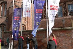 Ruderinnen hissen WM-Fahnen vor dem Rathaus