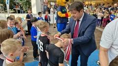 Oberbürgermeister Steffen Scheller hilft beim Verteilen der Medaillen.