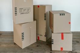 Umzugskartons stehen gestapelt auf dem Boden. Bild: RODNAE Productions von Pexels