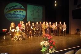 Gruppenbild der Geehrten mit Oberbürgermeisterin, SVV-Vorsitzenden, Moderatoren und Hund Ballu.