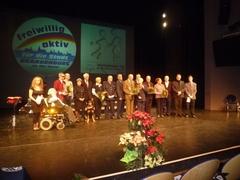 Gruppenbild der Geehrten mit Oberbürgermeisterin, SVV-Vorsitzenden, Moderatoren und Hund Ballu.