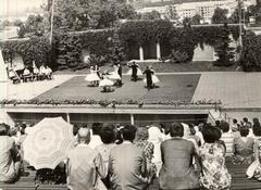 Veranstaltung auf der Freilichtbühne. Die Freilichtbühne ist von hinteren Plätzen aus zu sehen. Im Hintergrund tanzen Paare auf der Bühne, im Vordergr