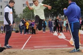 Ein Junge springt in die Weitsprunggrube.