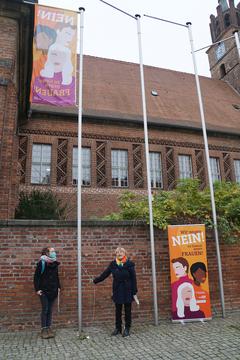 Gleichstellungsbeauftragte Kornelia Köppe (rechts) hisst gemeinsam mit Juliane Moosdorf, Leiterin des Arbeitskreises "Keine Gewalt gegen Frauen" die Antigewaltfahne "Wir sagen Nein! zu Gewalt gegen Frauen!" am Altstädtischen Rathaus