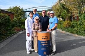 6 Personen stehen um eine Tonne herum, welche mit Benefizregatta beschriftet ist.