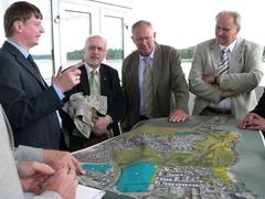 Beigeordneter Michael Brandt erläutert auf dem Zielrichterturm der Regattastrecke BGL-Präsident Hanns-Jürgen Redeker (rechts) und weiteren Experten die BUGA-Pläne