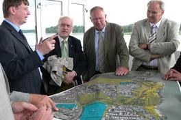 Beigeordneter Michael Brandt erläutert auf dem Zielrichterturm der Regattastrecke BGL-Präsident Hanns-Jürgen Redeker (rechts) und weiteren Experten die BUGA-Pläne