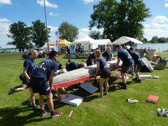 Studenten heben ein Betonkanu an