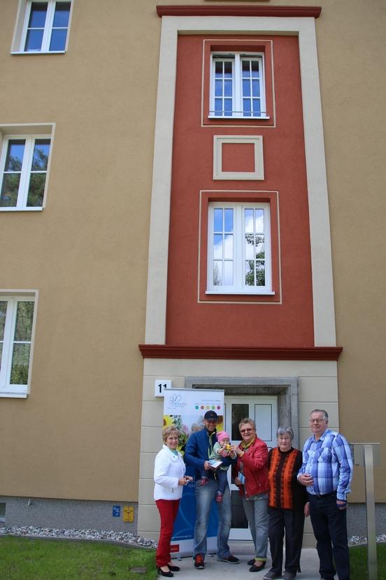 Oberbürgermeisterin Dr. Dietlind Tiemann, Dirk Zimmermann und Töchterchen Elli, Doris Seeber und Ehepaar Lubowietzki vor einem neu sanierten Haus am Platz der Einheit