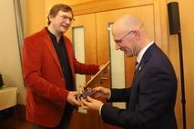 Industriemuseumschef Marius Krohn überreichte ein rotes Fahrrad im Miniformat.