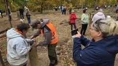 Frau fotografiert das Anbringen einer Namensplakette.