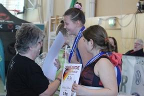 einem Mädchen wird eine Medaille um den Hals gehängt