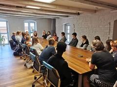 Große gruppe an langen Tischen Sitzend