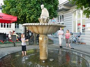 Ansicht des Brunnens mit einem Kind welches darin steht