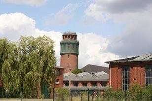 Wasserturm mit Industriegebäuden im Vordergrund