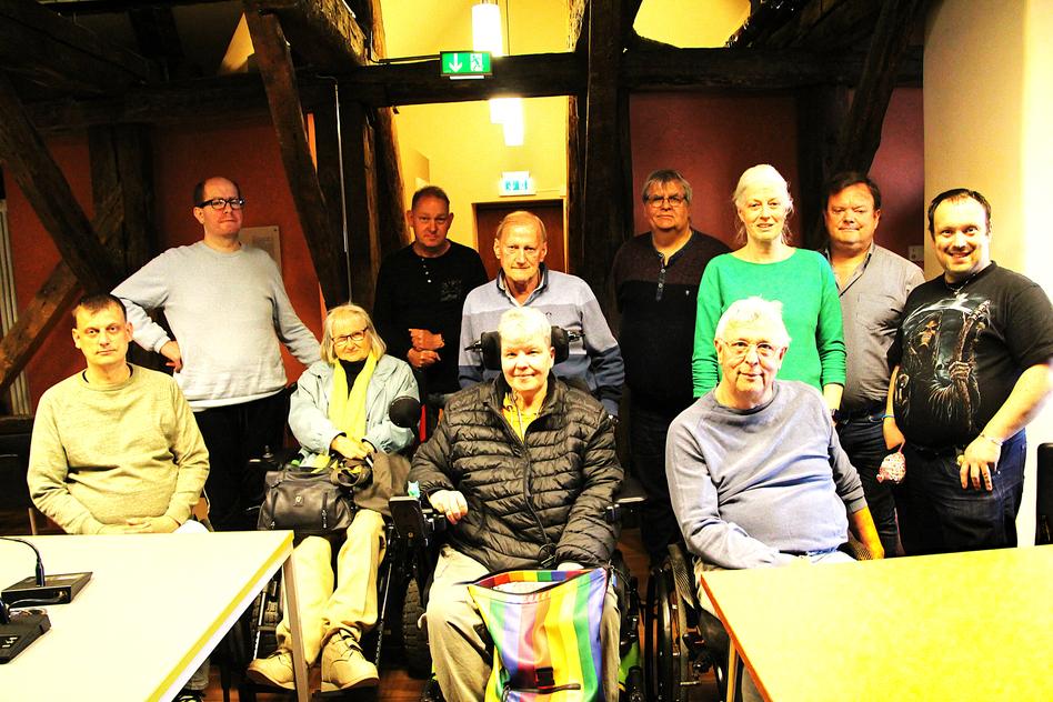 Gruppenbild im Besprechungsraum mit dicken Balken.