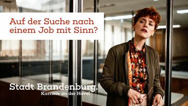 eine Frau steht im Büro und schaut sich suchend um, Text: Auf der Suche nach einem Job mit Sinn? Stadt Brandenburg. Karriere an der Havel