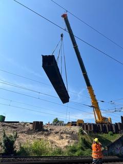 Die beiden tragenden Hohlkästen wurden jeweils halbiert und auf den Brückenrampen niedergelegt.