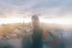 Fot von einer Frau mit Blick über die Dächer der Stadt bis zur Friedenswarte
