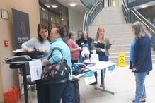 Eine ältere Besucherin informiert sich an einem Stand zu Maßnahmen bei Hitze