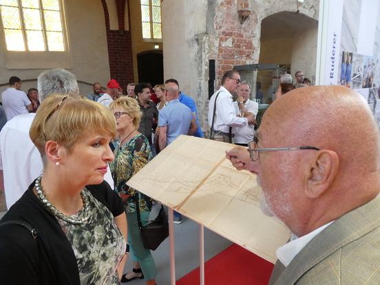 Hartmut Töpel, einer der "Väter der Regattastrecke", erläutert Kulturministerin Martina Münch bei der Ausstellungseröffnung seinen mehr als 50 Jahre alten Original-Plan. 