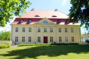 Zweistöckiges Gebäude und einer grünen Wiese im Vordergrund