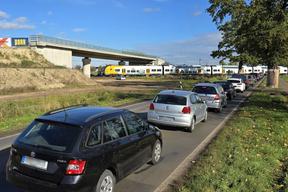 geschlossener Bahnübergang mit wartenden Autos