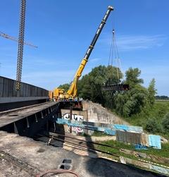 Die beiden tragenden Hohlkästen wurden jeweils halbiert und auf den Brückenrampen niedergelegt.
