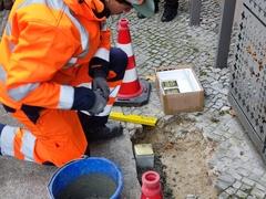 Nahaufnahme der Bauarbeiten zum Einsetzen des goldenen Steins in das Kopfsteinpflaster