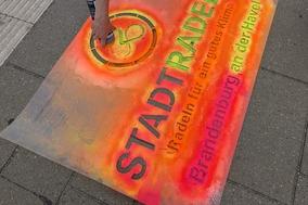 Besprühen eines Radweges mit einem Stadtradel-Logo.