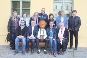 Bezirksschulleiter neben der Holzfigur Loriot