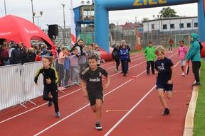 Mehrere Kinder laufen durch den Zielbogen nach einem Sprint.